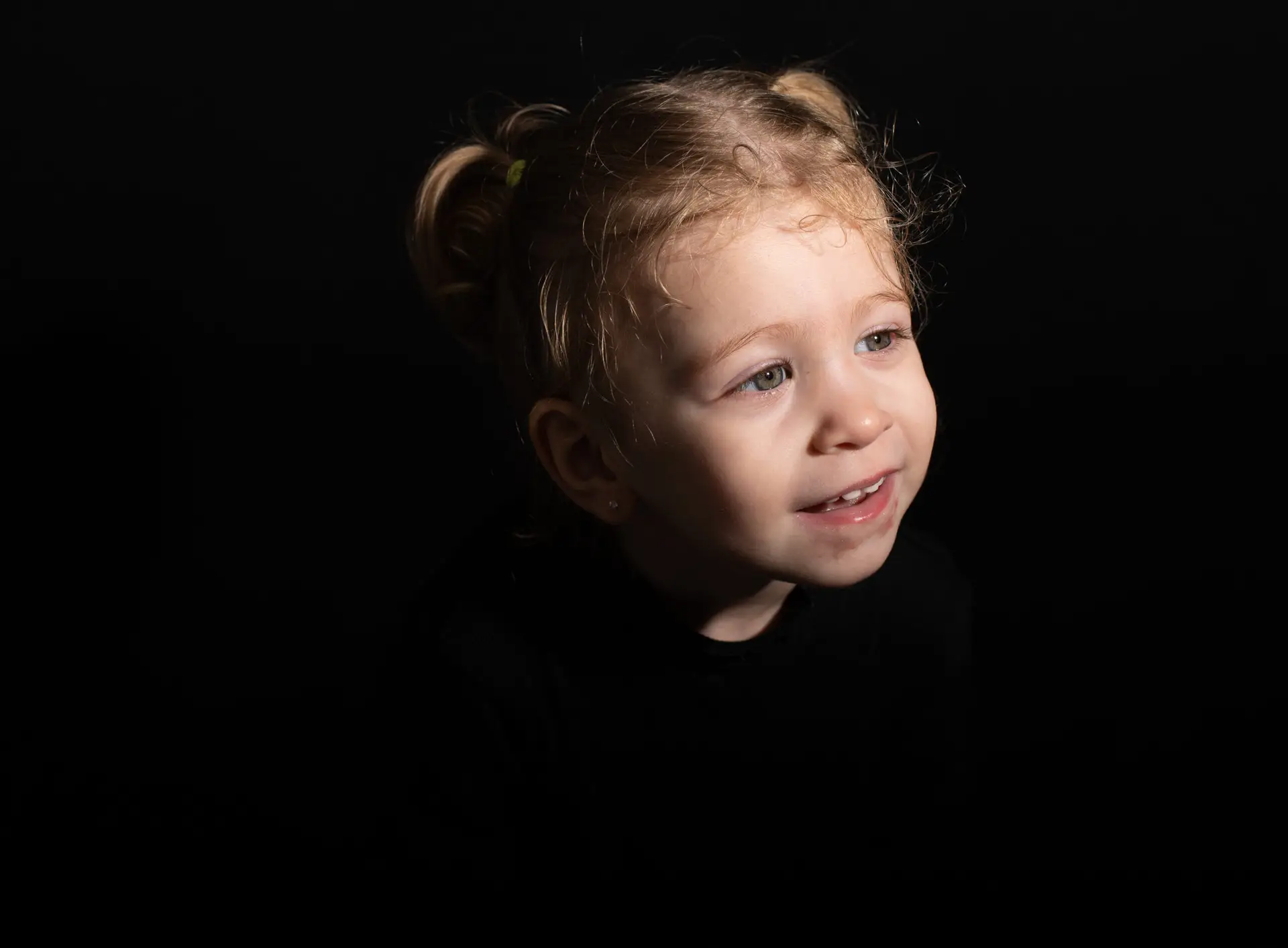 Expression joyeuse enfant , plongé dans le noir , le visage illuminé